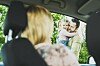 Frau im Auto blickt auf Mann mit Kind vor grüner Hecke; Abschiedsszene