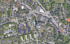 Luftaufnahme eines Stadtteils mit Häusern, Straßen, Gewerbebauten und viel Grün.