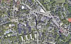 Luftaufnahme eines Stadtteils mit Häusern, Straßen, Gewerbebauten und viel Grün.