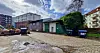 Hinterhof an der Leverkusenstraße 16A mit Pflasterfläche, Mülltonnen, Baufahrzeugen und angrenzenden Gebäuden.