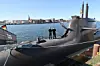 U-Boot im Hafen, zwei Personen auf dem Deck, Stadt skyline im Hintergrund