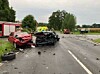 Zwei schwer beschädigte Autos auf der L135 nach einem Unfall, Trümmerteile liegen auf der Straße.