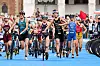 Lisa Tertsch und weitere Triathletinnen laufen mit Rädern durch die Wechselzone.