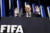 Gianni Infantino hebt beim FIFA-Kongress in Paris beide Hände hinter dem FIFA-Pult.