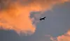 TUI-fly-Boeing 737 als Silhouette vor orangefarbenem Morgenhimmel über Hannover.