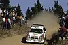Lancia Delta S4 driften auf Schotter, Zuschauer am Rand, dichte Staubwolke bei der Rallye Argentinien.