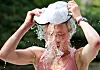 Läuferin gießt sich bei Halbmarathon in Hamburg Wasser aus der Mütze über den Kopf.