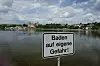 Ein Schild mit der Aufschrift „Baden auf eigene Gefahr“ steht am Ufer des Süßen Sees bei den See-Terrassen Seeburg. Experten warnen aufgrund gestiegener Wassertemperaturen vor Vibrionen.