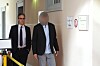 Jonathan G. mit Anwalt auf dem Flur des Landgerichts Hamburg vor dem Gerichtssaal; Personen teils gepixelt.