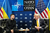 Trump und Selenskyj sitzen sich in Ankara beim NATO-Gipfel vor NATO-, USA- und Ukraine-Flaggen gegenüber.