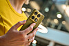 Person hält ein golden-olives Motorola Signature vor unscharfem Hintergrund.