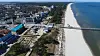 Sandstrand auf Usedom mit Seesteg, Ostsee und Küstenbebauung im Hintergrund.