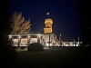 Beleuchtetes Restaurant mit dem historischen Bismarckturm bei Nacht.