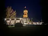 Beleuchtetes Restaurant mit dem historischen Bismarckturm bei Nacht.