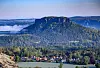 Lilienstein über Waldlandschaft und Dorf im Elbtal, im Morgenlicht.