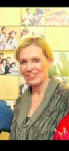 Frau vor einer Wand mit mehreren kleinen Fotos und angeschnittenen Personen im Vordergrund.