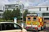 Rettungswagen vor den Westküstenkliniken in Heide, daneben ein Polizeifahrzeug auf dem Klinikgelände.