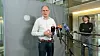 Mann spricht vor Mikrofonen im Bundeskanzleramt.