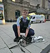 Polizist versorgt am Bahnhof Dammtor eine gerettete Graugans; Einsatzfahrzeug der Bundespolizei im Hintergrund.