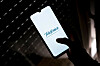 Hand hält Smartphone mit Telefónica-Logo in dunkler Umgebung