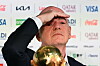 Gianni Infantino bei FIFA-Pressekonferenz, vor ihm eine goldene Trophäe und Sponsorlogos im Hintergrund.
