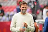 Jürgen Klopp im weißen Pullover hält eine Wasserflasche im BC Place in Vancouver.
