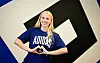 Paulina Bartz im HSV-Trikot vor großem Vereinslogo, lächelnd mit Herzgeste.