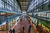 Wandelhalle im Hamburger Hauptbahnhof mit Passanten, Läden und hoher Glas- und Stahlkonstruktion.