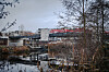 Fußgängerbrücke über den Schleusengraben in Bergedorf, dahinter moderne Gebäude und Bäume am Ufer.