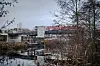 Fußgängerbrücke über den Schleusengraben in Bergedorf, dahinter moderne Gebäude und Bäume am Ufer.