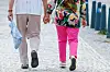 Älteres Paar geht Hand in Hand über eine gepflasterte Straße im Stadtzentrum.