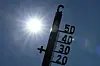 Thermometer-Silhouette vor gleißender Mittagssonne, Temperaturen bis 40 Grad Celsius angekündigt.