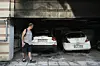 Mann vor einer schlammigen Tiefgarage mit zwei teilweise überfluteten Autos.