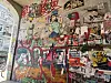 Graffiti- und stickerbedeckte Betonwand unter einem Bogen