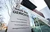 Beschilderung am Haus der Gerichte in Hamburg vor moderner Glasfassade.