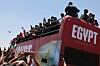 Ägyptische Fans begrüßen die Nationalmannschaft am Flughafen El Alamein mit Fahnen und Applaus.