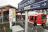 S-Bahn am Bahnhof Othmarschen in Hamburg, Reisende stehen am Bahnsteig unter dem Stationsschild.