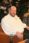 Albertus Akkermann sitzt in einer Talkshow in Hamburg, im Hintergrund fotografieren Kameraleute.