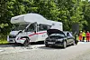 Beschädigtes Wohnmobil und schwarzer Pkw nach Zusammenstoß; Einsatzkräfte stehen rechts an der Unfallstelle.