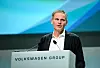 Mann am Rednerpult von Volkswagen Group vor blauem Bühnenhintergrund.