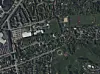 Luftaufnahme eines Wohnviertels mit Straßen, Häusern, Grünflächen und Sportanlagen.