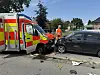 Rettungswagen nach Kollision mit VW und zwei parkenden Autos in Wiemersdorf, Einsatzkräfte vor Ort.