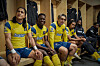 Cristo Fernandez, Toheeb Jimoh, Phil Dunster und Moe Hashim sitzen in gelb-blauen Fußballtrikots in einer Umkleidekabine.