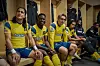 Cristo Fernandez, Toheeb Jimoh, Phil Dunster und Moe Hashim sitzen in gelb-blauen Fußballtrikots in einer Umkleidekabine.