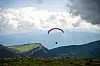 Gleitschirmflieger über den Bergen am Monte Baldo am Gardasee in Italien