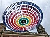 Regenbogenfarbene Schirme über historischer Fassade