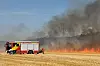 Feuerwehr bekämpft Flächenbrand auf Stoppelacker bei Elsenfeld, dichte Rauchwolken steigen auf.