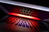 Laptop-Tastatur spiegelt sich im Bildschirm mit rotem Licht und Zoom-Effekt.