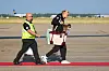 Erling Haaland geht mit Geschenkbox und kleinem Hund über das Vorfeld am Flughafen Oslo.