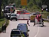 Rettungskräfte und Einsatzfahrzeuge sichern eine Unfallstelle auf einer kurvigen Landstraße ab.